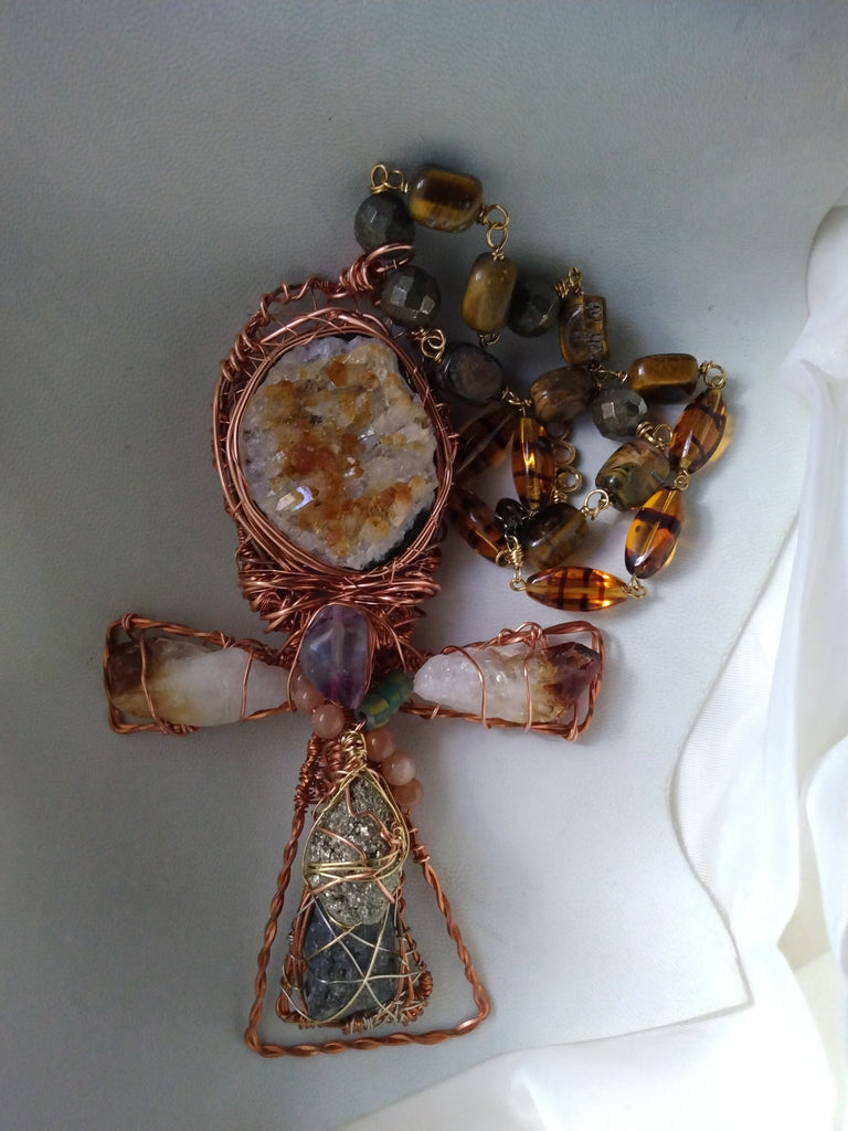 Hand wrapped citrine druzy ankh pendant displayed as handmade spiritual jewelry 